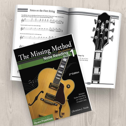 The Missing Method for Guitar Note Reading Book 1 Paperback on table displaying the front cover and another copy open, displaying pages 8-9