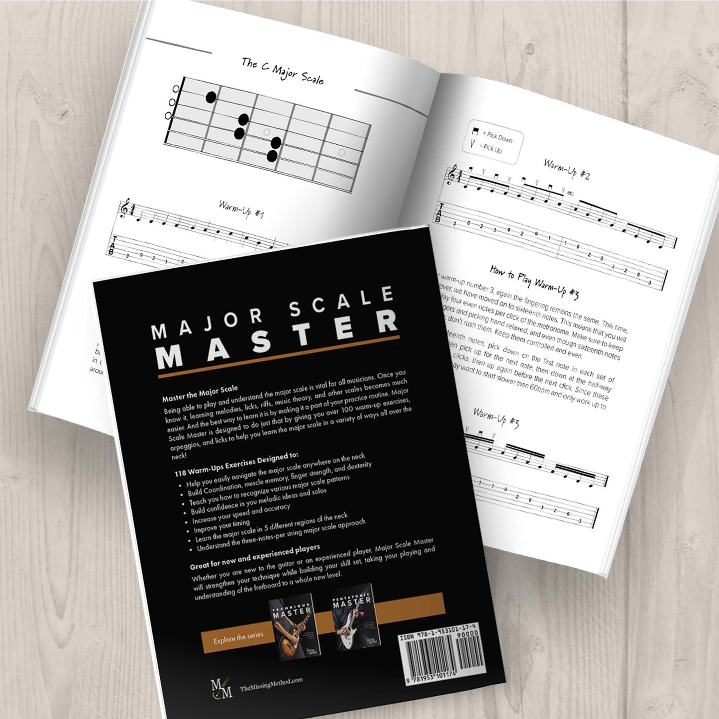 Major Scale Master from The Missing Method for Guitar. Image of two copies of the paperback book on a tabletop, one open displaying pages of the book, and the other closed, displaying the back cover.