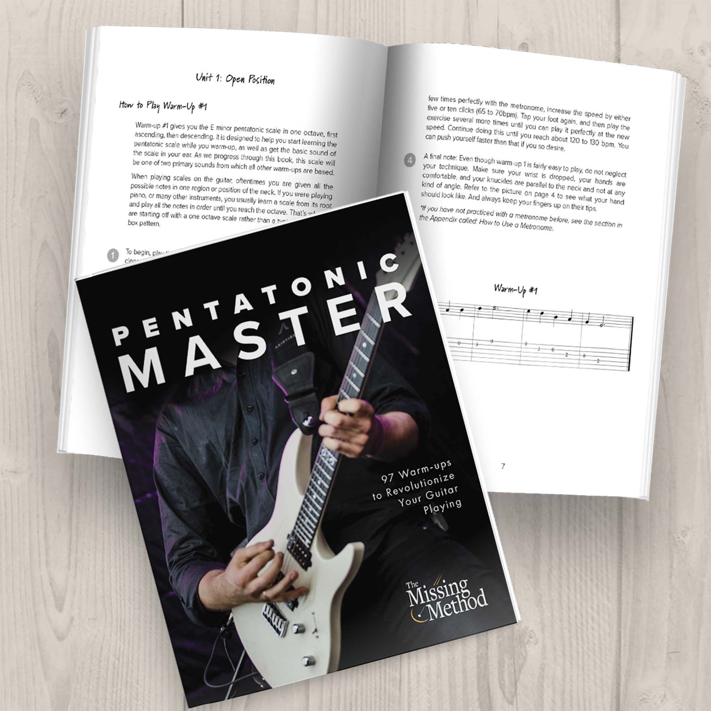 Pentatonic Master from The Missing Method for Guitar.  Two copies of the book are displayed on a table. One copy is open, displaying the first pages of the first unit. The other copy of the book is closed, displaying the front cover.