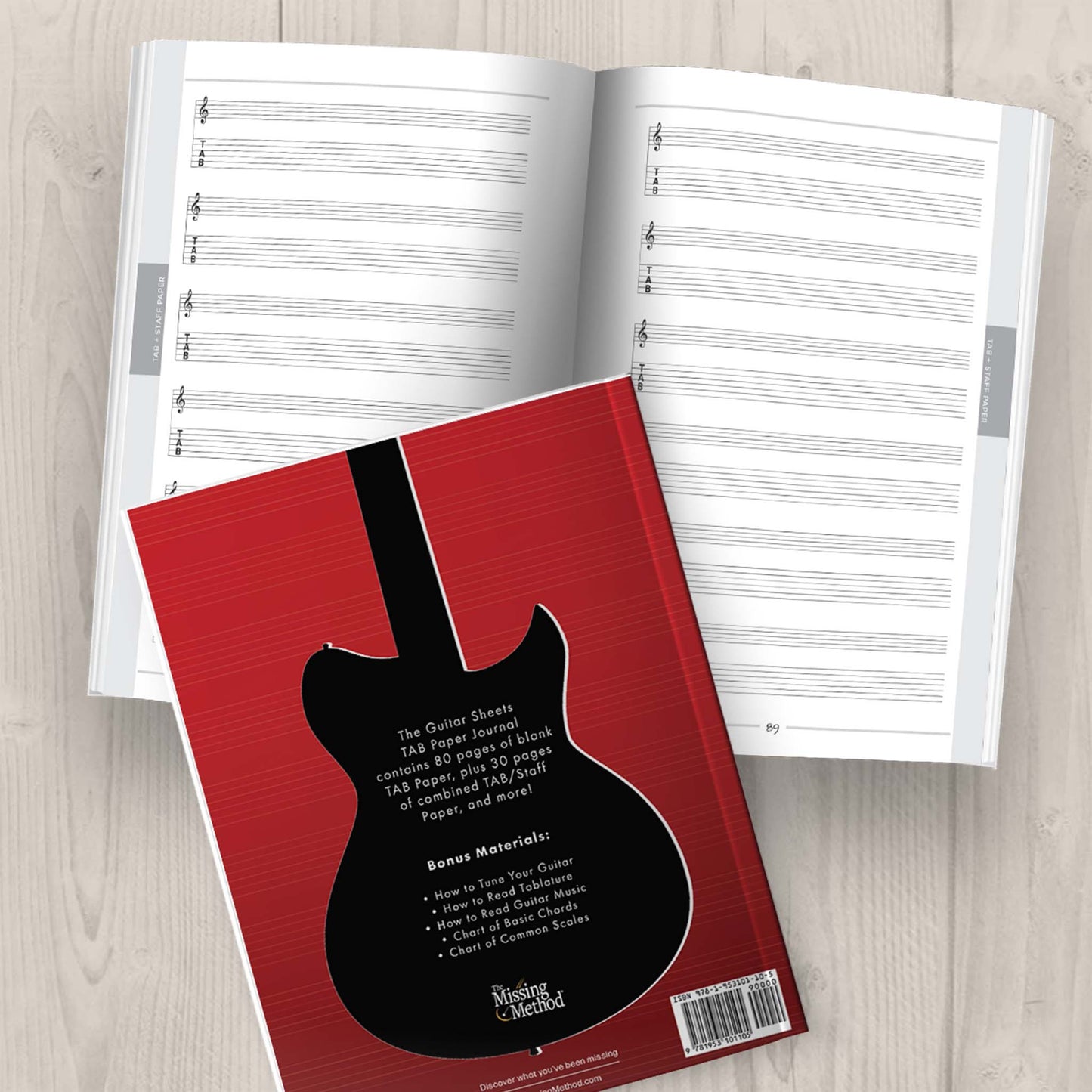 Guitar Sheets TAB Paper Journal from The Missing Method for Guitar, closed book displaying back cover and open book displaying pages on a tabletop